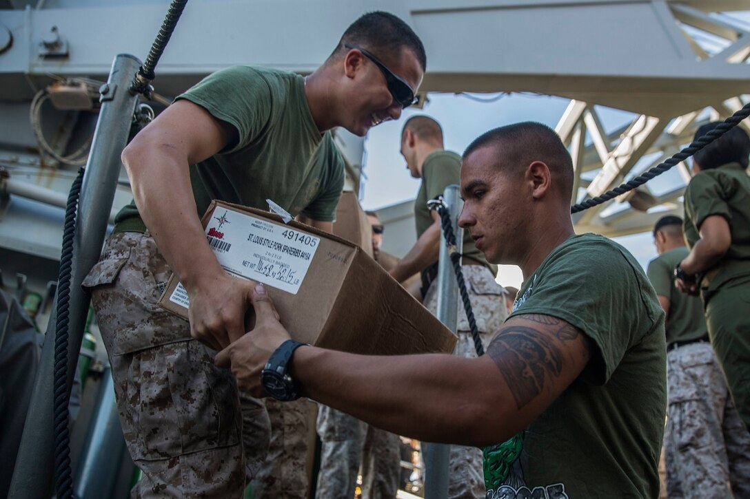 U.S. Marines with the 15th Marine Expeditionary Unit assist with offloading boxes during replenishment at sea aboard the USS Rushmore (LSD 47) at sea in the Pacific Ocean, May 31, 2015. Marines and Sailors worked together to off load supplies and mail from loved ones. (U.S. Marine Corps photo by Sgt. Emmanuel Ramos/Released)