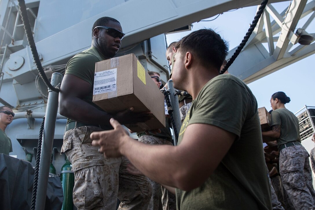 U.S. Marines with the 15th Marine Expeditionary Unit move boxes during replenishment at sea aboard the USS Rushmore (LSD 47) at sea in the Pacific Ocean, May 31, 2015. Marines and Sailors worked together to off load supplies and mail from loved ones. (U.S. Marine Corps photo by Sgt. Emmanuel Ramos/Released)