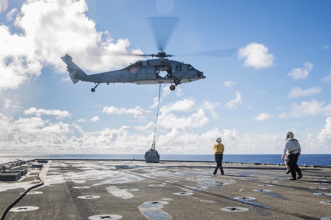 U.S. Sailors with the Essex Amphibious Ready Group prepare to receive supplies during replenishment at sea aboard the USS Rushmore (LSD 47) at sea in the Pacific Ocean, May 31, 2015. Marines and Sailors worked together to off load supplies and mail from loved ones. (U.S. Marine Corps photo by Sgt. Emmanuel Ramos/Released)