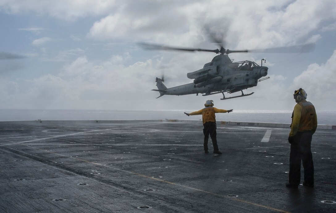 U.S. Navy Aviation Boatswain’s Aircraft Handling 3rd Class Joshua Naves, left, guides an AH-1Z Viper onto the flight deck aboard the USS Anchorage (LPD 23) at sea in the Pacific Ocean, May 30, 2015. Naves is an aircraft handler aboard the USS Anchorage. The Marines and Sailors of the 15th Marine Expeditionary Unit and Essex Amphibious Ready Group conduct flight operations to maintain expeditionary readiness. (U.S. Marine Corps photo by Cpl. Steve H. Lopez/Released)