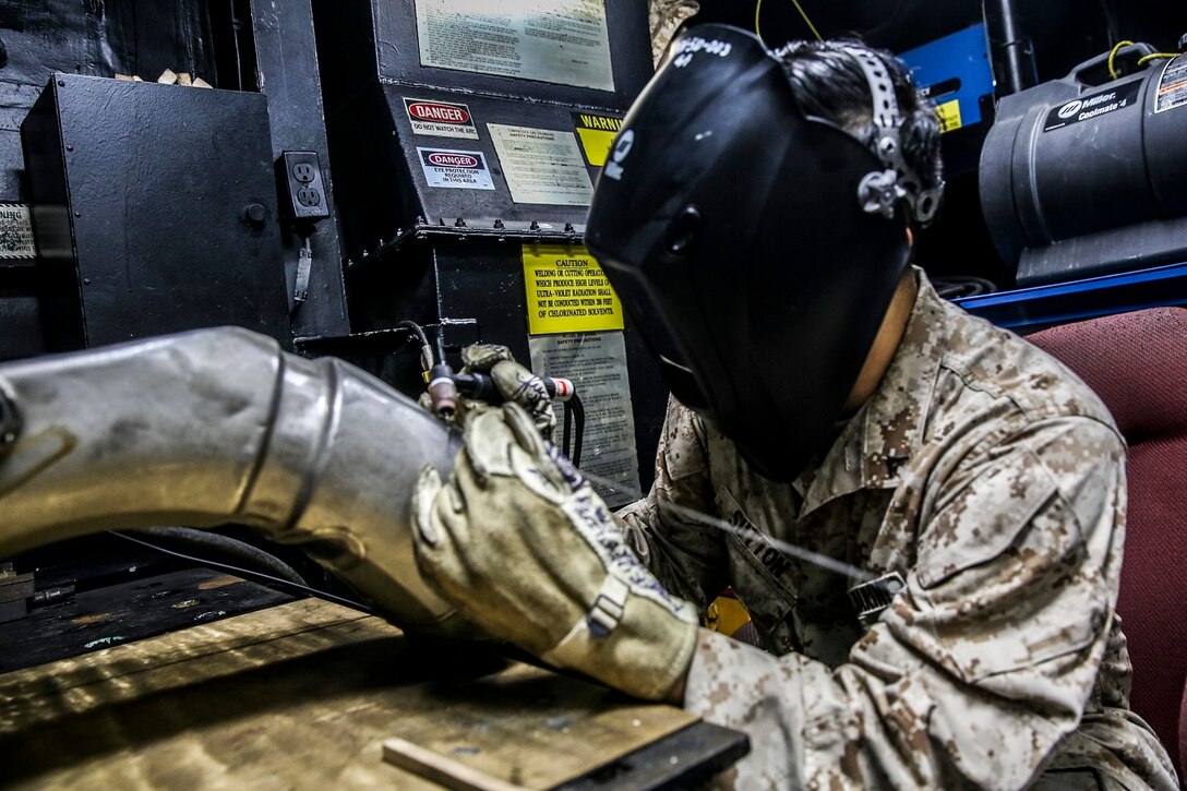 U.S. Marine Lance Cpl. William Sutton prepares to weld a CH-53E Super Stallion’s oil tank aboard the USS Essex (LHD 2) at sea in the Pacific Ocean, May 30, 2015. Sutton is an airframes and structures technician with the Aviation Intermediate Maintenance Department, Medium Marine Tiltrotor Squadron 161 (Reinforced), 15th Marine Expeditionary Unit. The Marines with the AIMD shop work together to repair aircraft parts in order to keep the helicopters flying and the crew members and pilots safe. (U.S. Marine Corps photo by Cpl. Anna Albrecht/ Released)