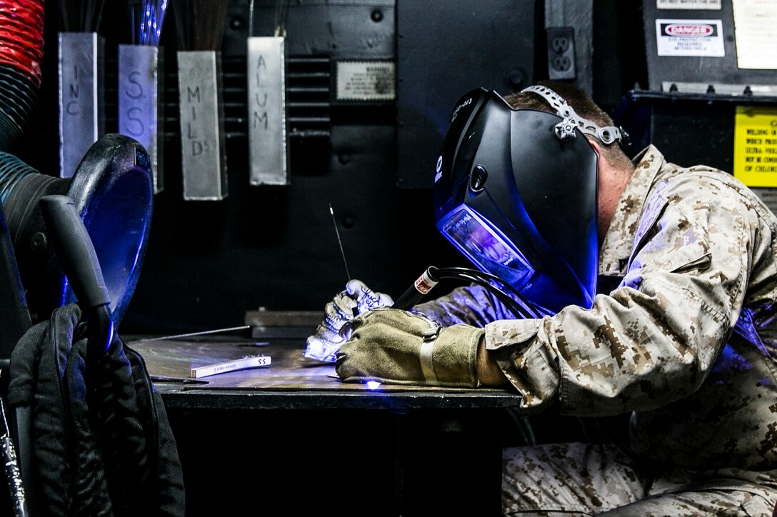 U.S. Marine Lance Cpl. Brock Prater practices torch work aboard the USS Essex (LHD 2) at sea in the Pacific Ocean, May 30, 2015. Prater is an airframes and structures technician with the Aviation Intermediate Maintenance Department, Medium Marine Tiltrotor Squadron 161 (Reinforced), 15th Marine Expeditionary Unit. Prater specifically works with UH-1Y Venoms and MV-22B Ospreys. His job is to repair aircraft parts to keep them working properly. (U.S. Marine Corps photo by Cpl. Anna Albrecht/ Released)