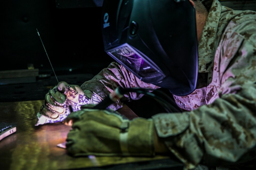 U.S. Marine Lance Cpl. Brock Prater practices torch work aboard the USS Essex (LHD 2) at sea in the Pacific Ocean, May 30, 2015. Prater is an airframes and structures technician with the Aviation Intermediate Maintenance Department, Medium Marine Tiltrotor Squadron 161 (Reinforced), 15th Marine Expeditionary Unit. Prater specifically works with UH-1Y Venoms and MV-22B Ospreys. His work can range from replacing bearings and links, to welding cracks in doors or oil tanks. (U.S. Marine Corps photo by Cpl. Anna Albrecht/ Released)