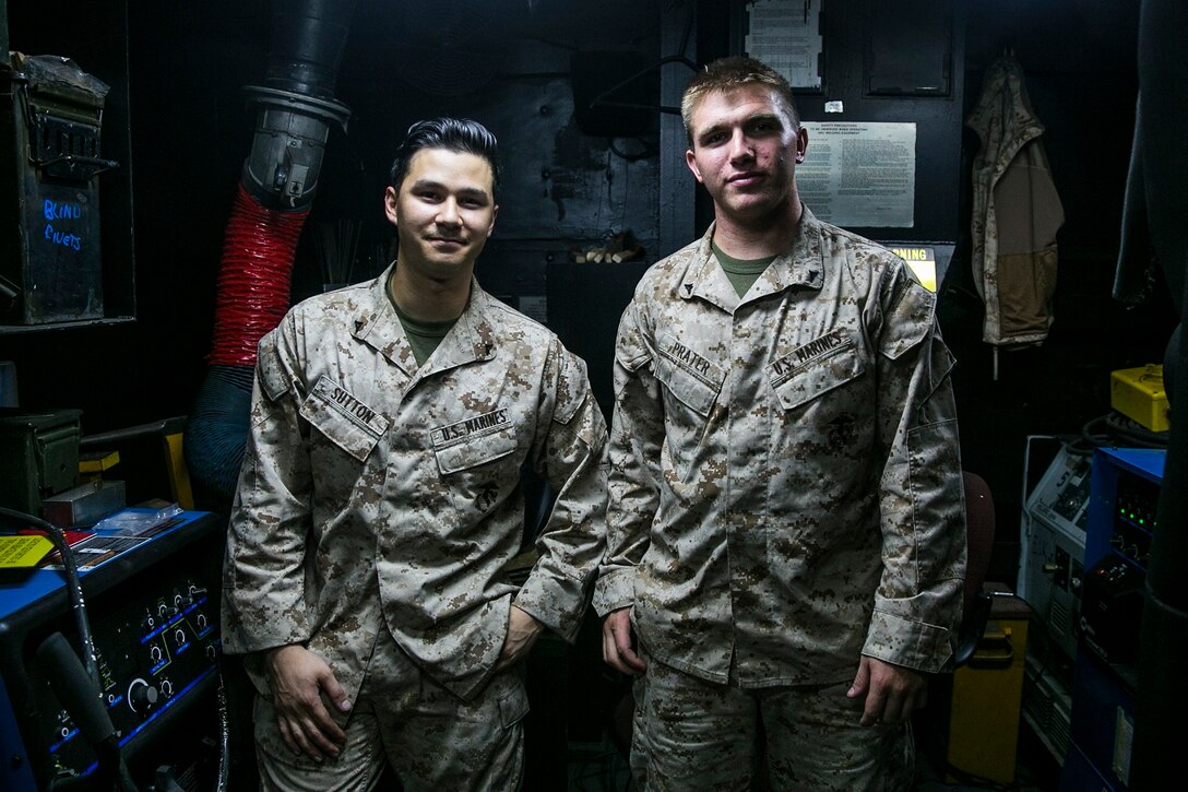 U.S. Marines Lance Cpl. William Sutton, left, and Lance Cpl. Brock Prater stand in their workshop aboard the USS Essex (LHD 2) at sea in the Pacific Ocean, May 30, 2015. Sutton and Prater are airframes and structures technicians with the Aviation Intermediate Maintenance Department, Medium Marine Tiltrotor Squadron 161 (Reinforced), 15th Marine Expeditionary Unit. The AIMD shop’s main purpose is to keep their aircraft flying. Their work can range from replacing bearings and links to welding cracks in doors or oil tanks. Along with keeping the birds flying and the crew members and pilots safe, they are involved in improving the quality of life for almost everyone on the Essex. These Marines receive special requests frequently and have finished a list of projects to assist operations and improve living conditions. Some of these projects include creating torpedo tubes from scratch to test metal detecting capabilities during Navy Aviation Ordnance training, and making tire-racks for the Aviation Supply Department to increase storage capabilities. The Marines also made water cooler covers and tables to augment the aesthetics of the wardroom. AIMD’s commitment to  the job, no matter how strange or how small, exemplifies the teamwork of the 15th MEU and Essex Amphibious Ready Group. (U.S. Marine Corps photo by Cpl. Anna Albrecht/ Released)