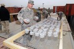 Army Sgt. 1st Class Erich Stemmerding, 534th Survey and Design Team, 15th Engineer Battalion, places “fuel donuts” on a drying rack Jan. 29, 2011, at Camp Phoenix in Kabul, Afghanistan. Once dry, the fuel donuts will burn for about an hour and provide an alternative heat source for Afghan families.