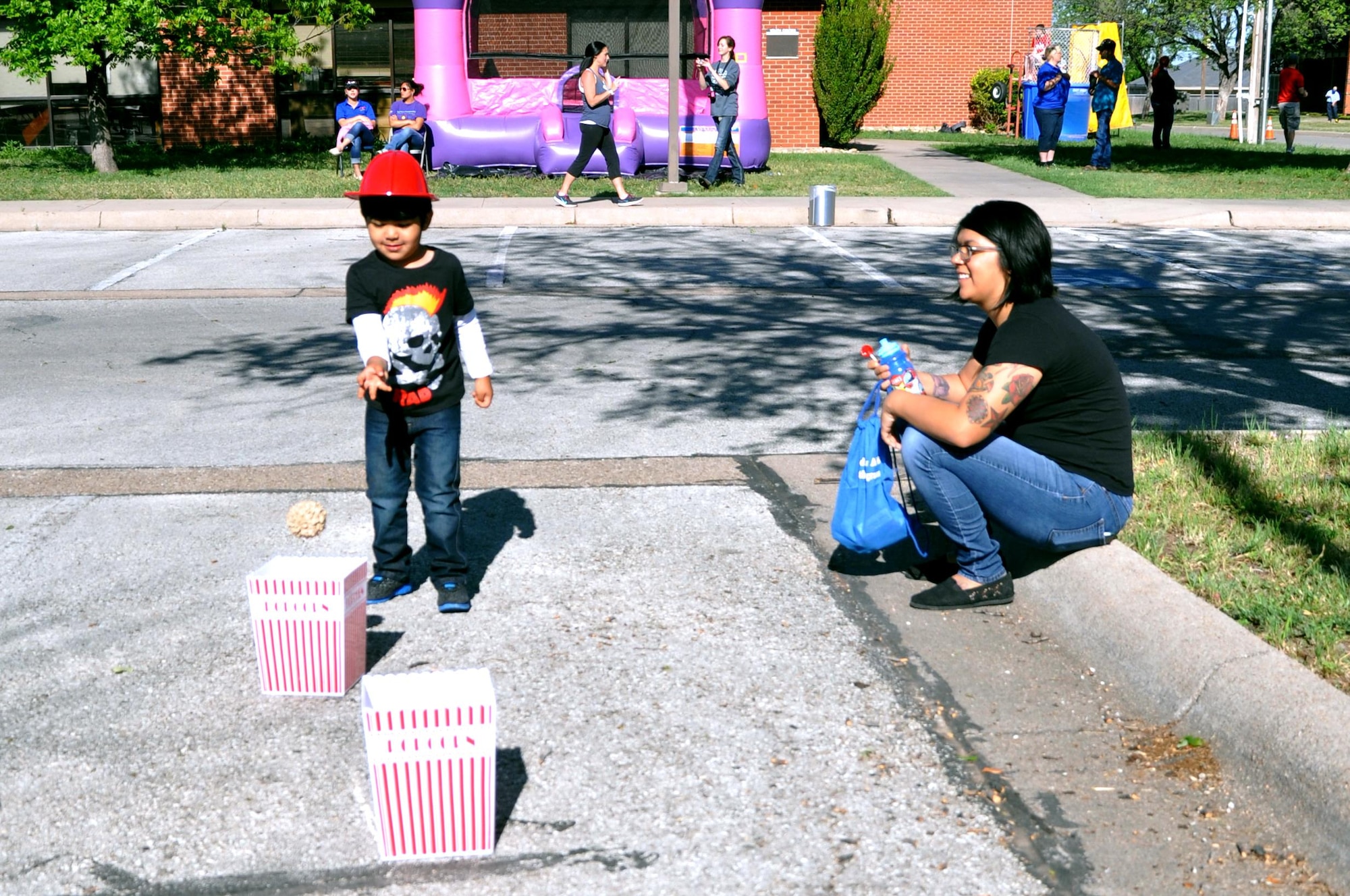 GOODFELLOW AIR FORCE BASE, Texas – Rocco Smith, Goodfellow youth, throws a ball into a popcorn bucket during the Month of the Military Child "What's Your Story" Children's Fair at the youth complex April 25. The event had several games where children could play for prizes. (U.S. Air Force photo/ Senior Airman Joshua Edwards)