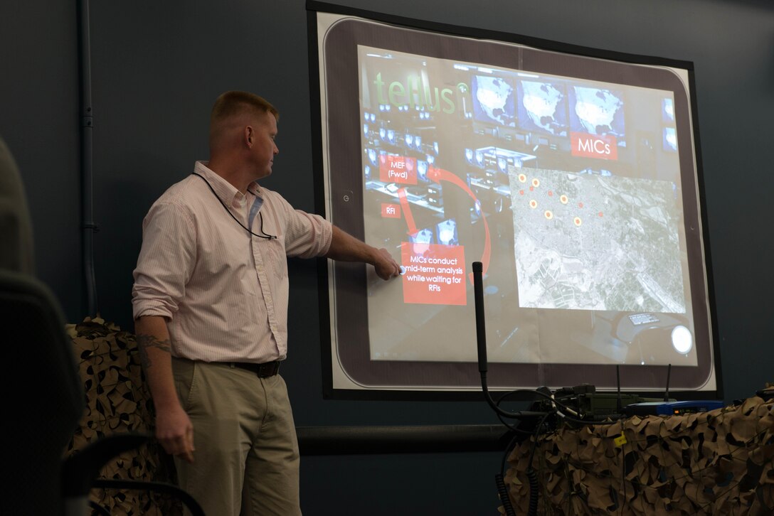 Staff Sgt. Joel Crenshaw, a cohort with the Accelerator team presents the new Tellus program to Brig. Gen. Michael Groen, the director of Marine Corps Intelligence during a presentation hosted by Mantech Spaces in Stafford, Va., May 29, 2015. Tellus is a program 