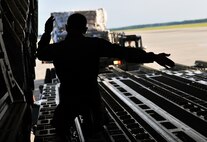 Tech. Sgt. Eric Blevins, 316th Airlift Squadron loadmaster, marshals a cargo loader toward a C-17 Globemaster, May 27, 2015, at Hurlburt Field, Fla. Members of the 823rd RED HORSE deployed to Honduras in support of NEW HORIZONS 2015, an annual event conducted to train military civil engineers and medical professionals to deploy and conduct joint operations. (U.S. Air Force photo by Airman 1st Class Ryan Conroy/Released)

