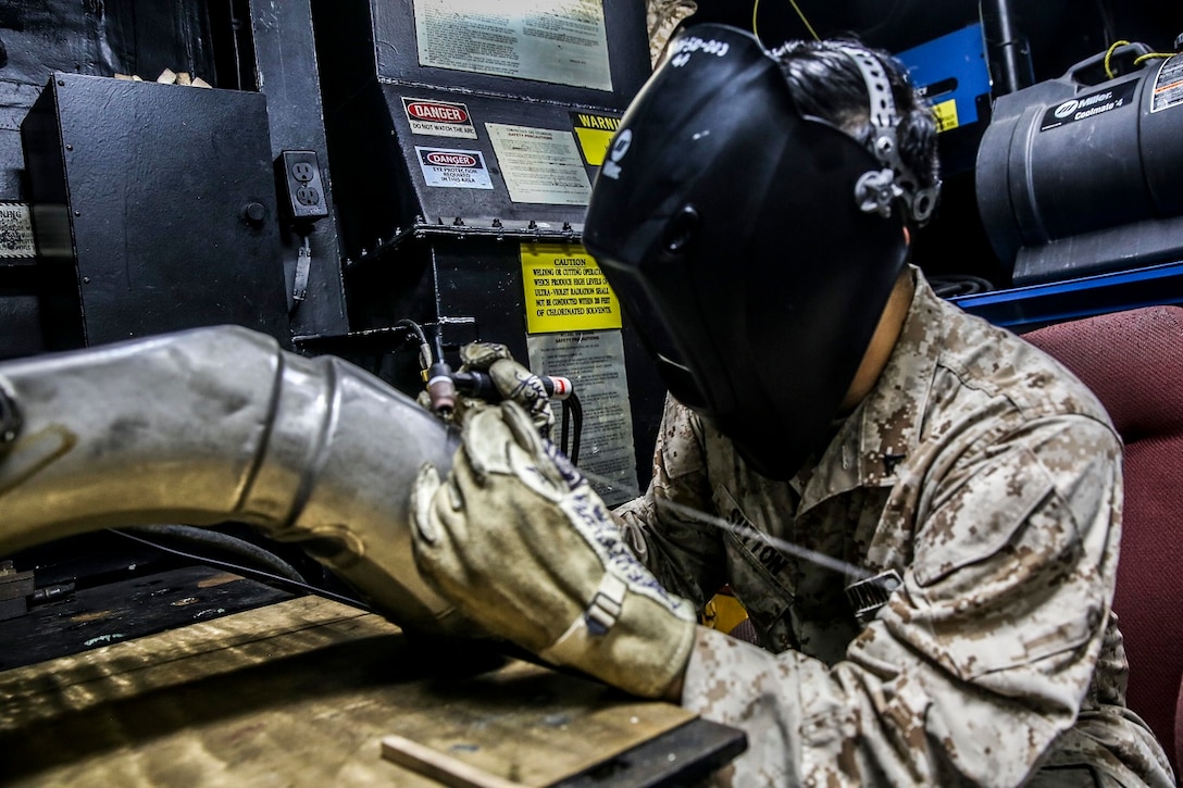 U.S. Marine Lance Cpl. William Sutton prepares to weld a CH-53E Super Stallion’s oil tank aboard the USS Essex (LHD 2) at sea in the Pacific Ocean, May 30, 2015. Sutton is an airframes and structures technician with the Aviation Intermediate Maintenance Department, Medium Marine Tiltrotor Squadron 161 (Reinforced), 15th Marine Expeditionary Unit. The Marines with the AIMD shop work together to repair aircraft parts in order to keep the helicopters flying and the crew members and pilots safe. (U.S. Marine Corps photo by Cpl. Anna Albrecht/ Released)