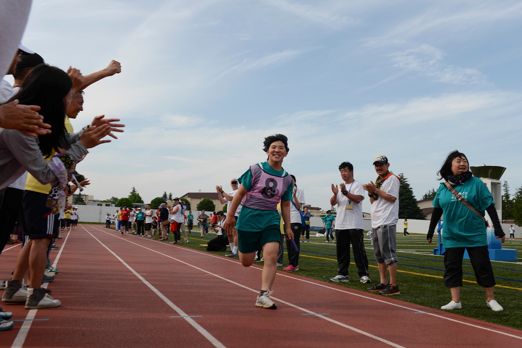 An athlete in the 36th Annual Kanto Plains Special Olympics participates in the 400 meter relay event at Yokota Air Base, Japan, May 30, 2015. Throughout the KPSO, athletes were surrounded by crowds of cheering volunteers. (U.S. Air Force photo by Airman 1st Class Elizabeth Baker/Released)