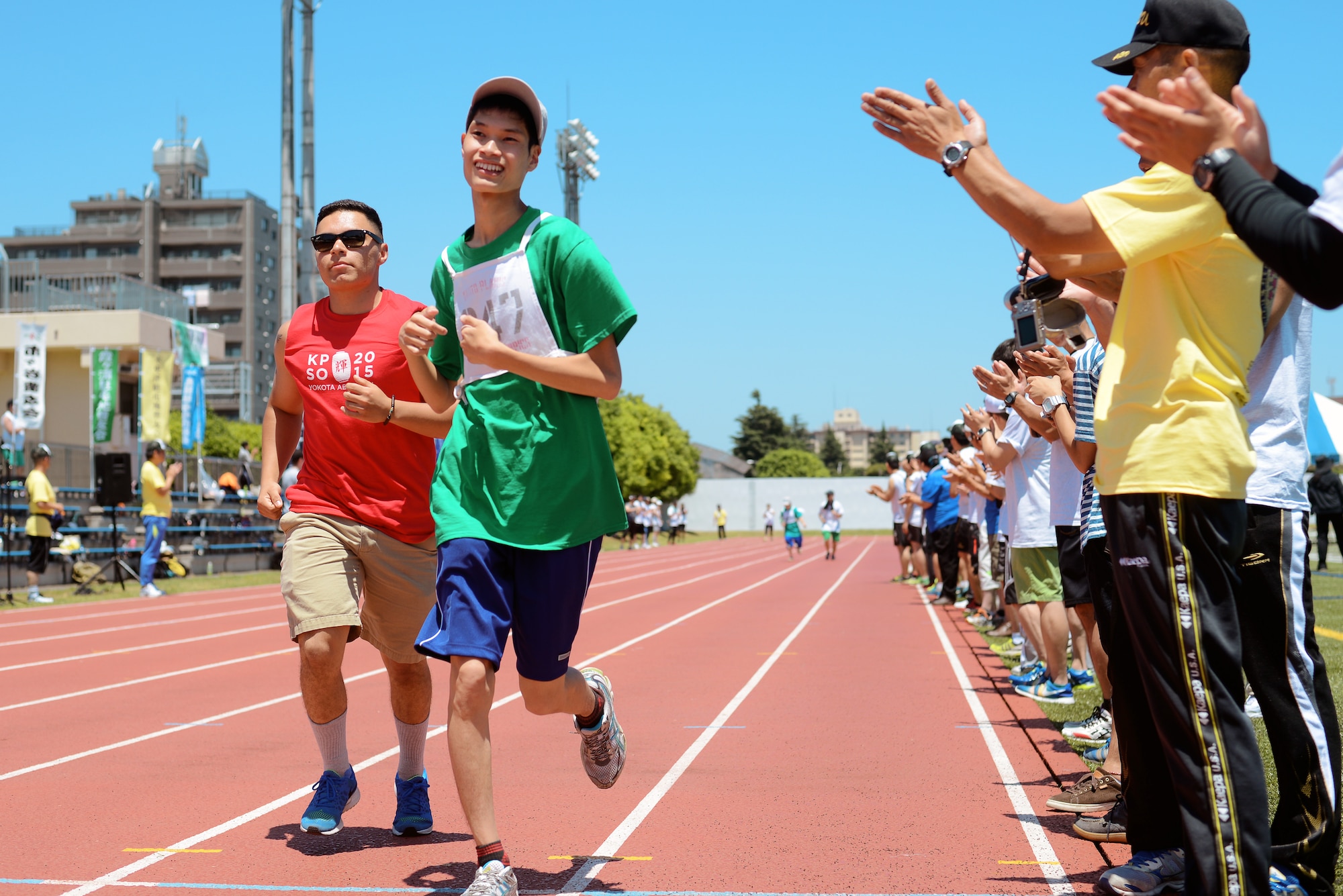 A Kanto Plains Special Olympics competitor is cheered on by spectators while running in the 100-meter dash May 30, 2015, at Yokota Air Base, Japan. In addition to track and field events, participants competed in a variety of sports including basketball, swimming and bowling. (U.S. Air Force photo by Airman 1st Class Delano Scott/Released)