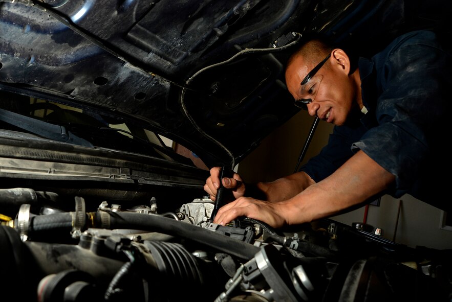Staff Sgt. Richard Quino, 799th Air Base Squadron vehicle management NCO in charge, inspects the engine bay of a government operated vehicle April 8, 2015, at Creech Air Force Base, Nevada. Quino also serves as the unit fitness program manager for the 799th ABS Vehicle Management section, the 799th ABS sports representative, the Life of a Warrior point of contact for Creech Air Force Base, Nevada and the Asian Pacific American Association president. (U.S. Air Force photo by Airman 1st Class Christian Clausen/Released)