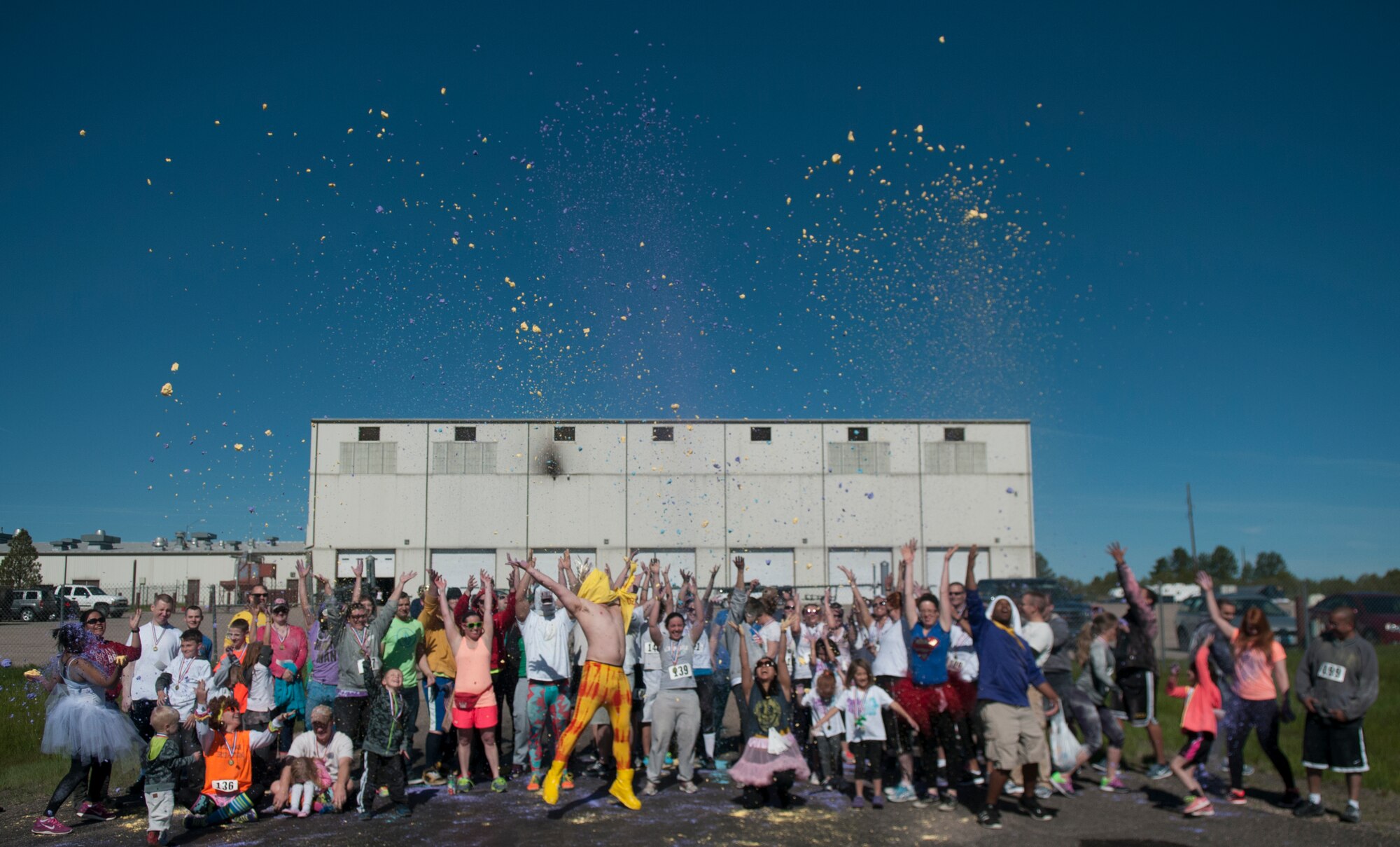 Participants and volunteers from the Air Force Sergeant’s Association 5-kilometer Color Run throw colored powder into the air to signify the end of the run May 30, 2015. The powder, a combination of corn starch and food coloring, was used to splash runners with color as they ran the 5k. (U.S. Air Force photo by Airman 1st Class Brandon Valle)
