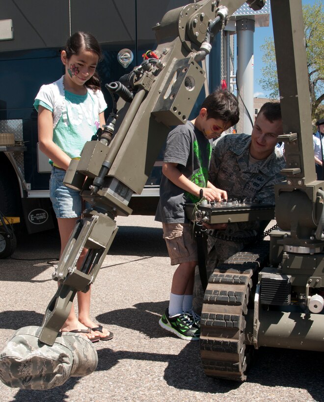 Senior Airman Eric Johnson, 90th Civil Engineer Squadron Explosive Ordnance Disposal team member, teaches Caleb, 7, and Cora Loya, 10, how to operate the EOD Wolverine robot used by the unit during the Military May event near the Cheyenne, Wyo., Capitol building. EOD showcased a number of tools they used to accomplish their mission to members of the local community. (U.S. Air Force photo by Airman 1st Class Malcolm Mayfield)