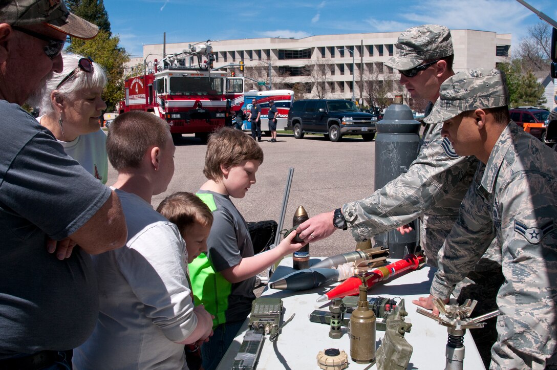 Tech. Sgt. Douglas Smits and Airman 1st Class Steven James, 90th Civil Engineer Squadron Explosive Ordnance Disposal team member, discuss with the community how different tools are used by the unit to accomplish their mission during the Military May event near the Cheyenne, Wyo., Capitol building May 30, 2015. Military May gave many Airmen from F.E. Warren Air Force Base, Wyo., the opportunity to show the community their mission and allow them to interact and learn about the tools they use to protect and defend the country. (U.S. Air Force photo by Airman 1st Class Malcolm Mayfield)