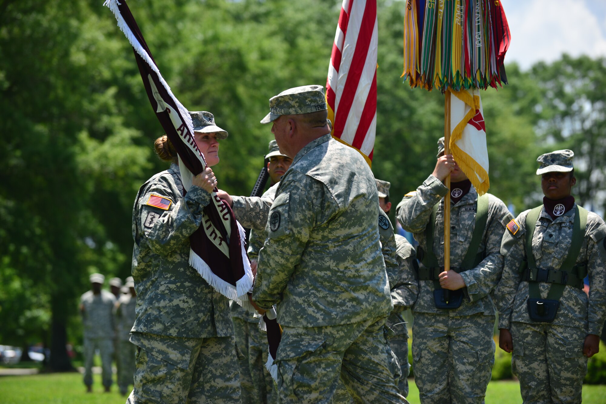 U.S. Army Brig. Gen. Robert D. Tenhent, U.S. Army North Regional Medical Command commander, passes the colors to Lt. Col. Heidi Mon, McDonald Army Health Center commander, during an assumption of command ceremony at Fort Eustis, Va., May 28, 2015. The passing of the colors from the commanding officer to the officer assuming command represents trust in the new commander’s leadership. (U.S. Air Force photo by Staff Sgt. Natasha Stannard/Released)