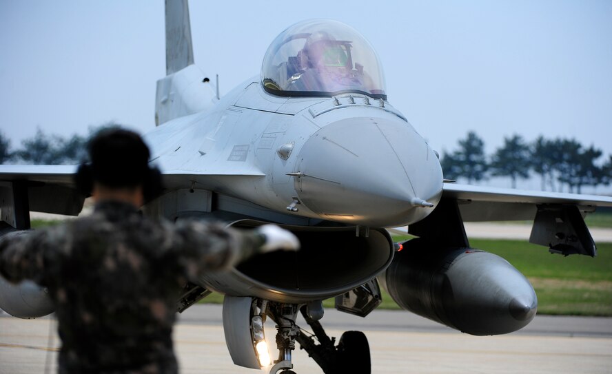 A Republic of Korean Air Force crew chief marshals an F-16 Fighting Falcon from the 123rd Fighter Squadron lands after a training sortie at Kunsan Air Base, Republic of Korea, June 1, 2015. In an effort to enhance U.S. and ROK Air Force’s combat capability, Buddy Wing exercises are conducted multiple times throughout the year on the peninsula improve interoperability between the allied forces so that if need be, they are always ready to fight as a combined force. (U.S. Air Force photo by Staff Sgt. Nick Wilson/Released)