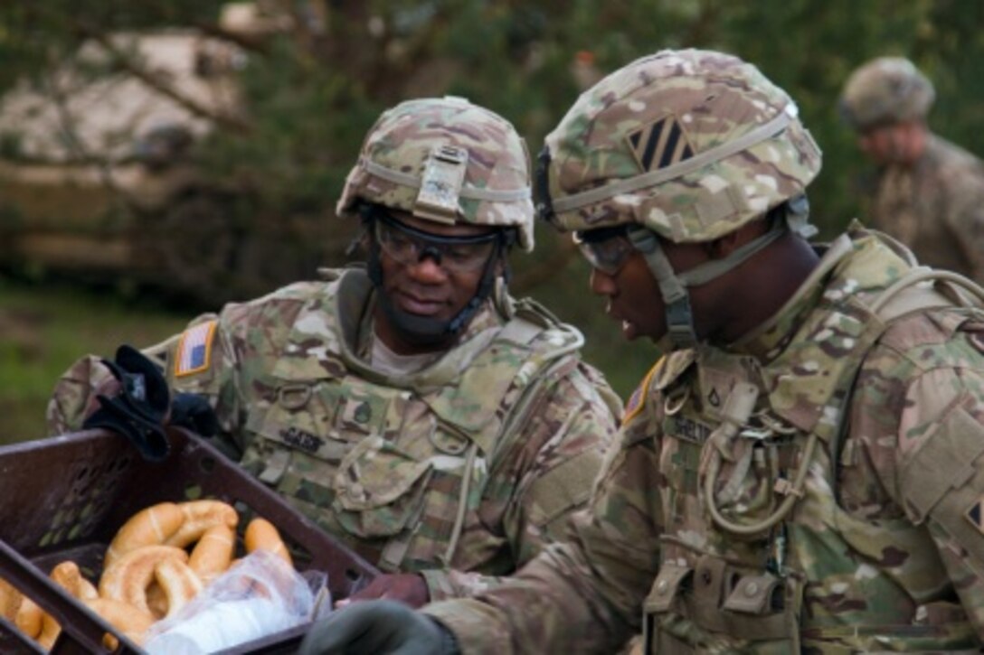 Army Staff Sgt. Marcus Carr Sr. and Army Pfc. Milton Shelton, supply specialists with Headquarters and Headquarters Company, 2nd Battalion, 7th Infantry Regiment, 1st Armored Brigade Combat Team, 3rd Infantry Division, deliver food to soldiers training at Camp Konotop, Poland, May 20, 2015,. U.S. Army photo by Spc. Marcus Floyd