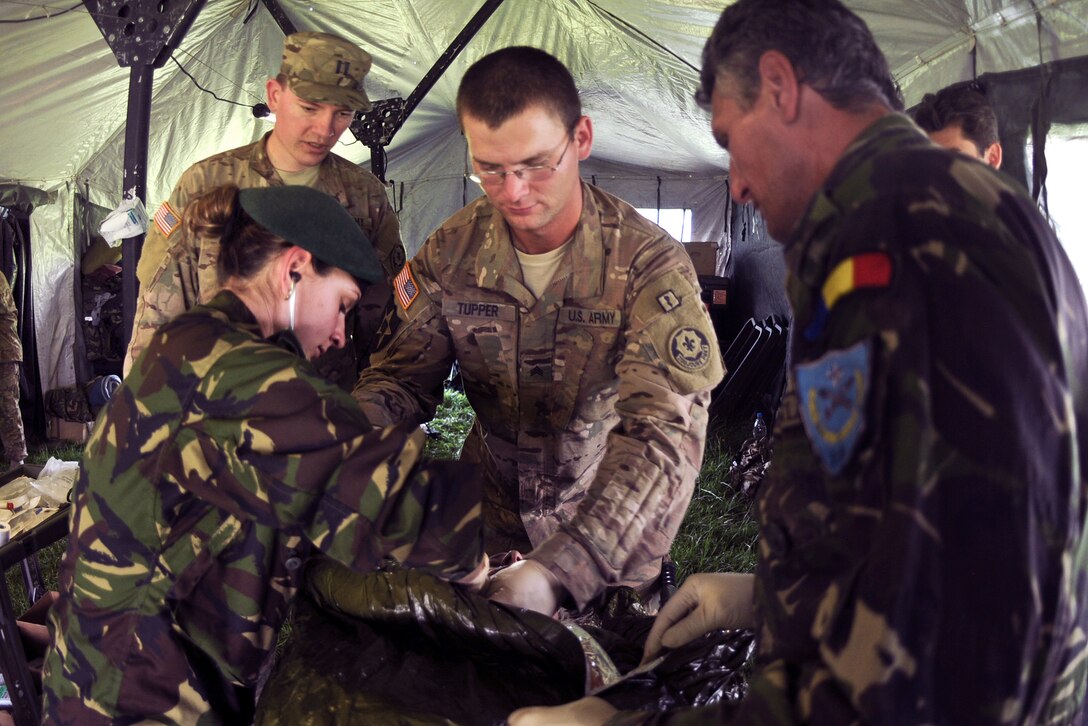 Romanian Land Forces Sgt. Ramona Nicolau, left, U.S. Army Capt. Nathaniel Watts, left, and U.S. Army Sgt. Christopher Tupper, middle, stabilize a patient while checking on his injuries and vital statistics during their Sarmis 15 Casualty Evacuation Training at the Cincu Training Area, Romania, May 30, 2015. Nicolau is a combat medic assigned to the 33rd Battalion, Romanian Land Forces; Watts is a field surgeon, and Tupper is a combat medic assigned to the 2nd Squadron, 2nd Cavalry Regiment.