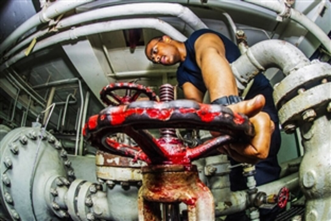 U.S. Navy Petty Officer 3rd Class Vincent McDonald operates an isolation valve for an arresting gear on the aircraft carrier USS George Washington in the waters near Guam, May 28, 2015. The Washington and Carrier Air Wing 5 are patrolling in the 7th Fleet area of responsibility supporting security and stability in the Indo-Asia-Pacific region.