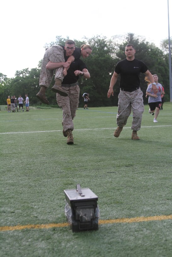 Marines of Recruiting Sub-station Leesburg demonstrate how to go through a customized team relay race May 19, 2015, at Herndon High School in Herndon, Virginia. Throughout the day, the Marines put multiple classes of students through a series of physically demanding exercises including ammunition can lifts, squad pushups and relay races. (U.S. Marine Corps photo by Sgt. Anthony Kirby/Released)