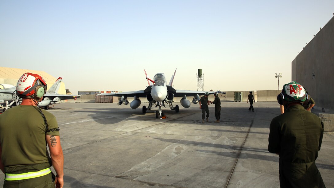 U.S. Marines of Marine Fighter Attack Squadron 232, Special Purpose Marine Air-Ground Task Force-Crisis Response-Central Command, finish the pre-flight inspection and prepare to guide the F/A-18 Hornet pilot to the runway for takeoff in Southwest Asia, May 28, 2015. Pilots of VMFA-232 support Combined Joint Task Force – Operation Inherent Resolve with a combination of surveillance flights and kinetic strike missions enabling Iraqi Security Forces in their fight against the Islamic State of Iraq and the Levant. 