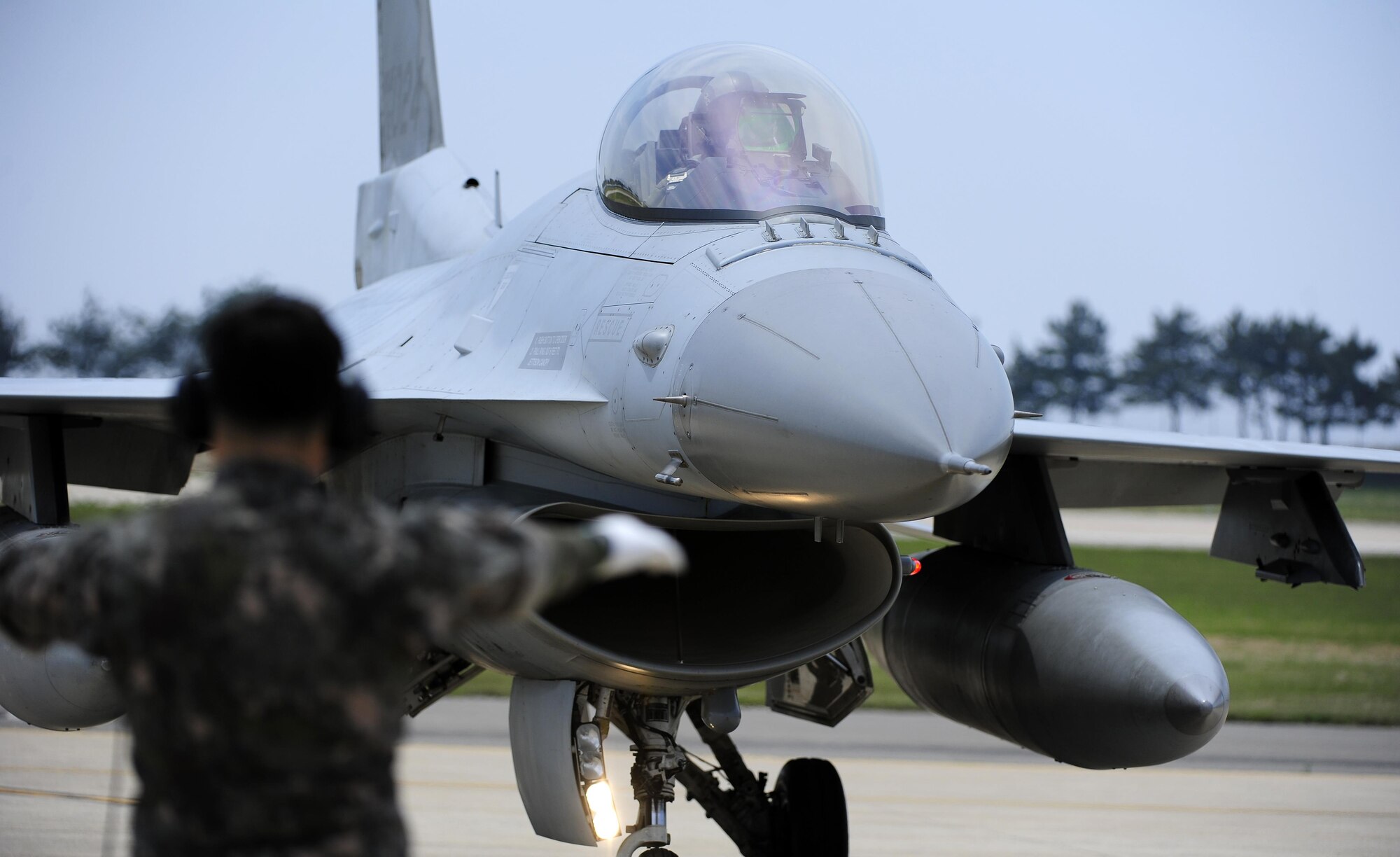 A South Korean air force crew chief marshals an F-16 Fighting Falcon from the 123rd Tactical Fighter Squadron, after it arrives at Kunsan Air Base, South Korea, for exercise Buddy Wing 15-4, June 1, 2015. In an effort to enhance U.S. and South Korean air force combat capability, Buddy Wing exercises are conducted multiple times throughout the year on the peninsula to sharpen interoperability between the allied forces so that if need be, they are always ready to fight as a combined force. (U.S. Air Force photo/Staff Sgt. Nick Wilson)
