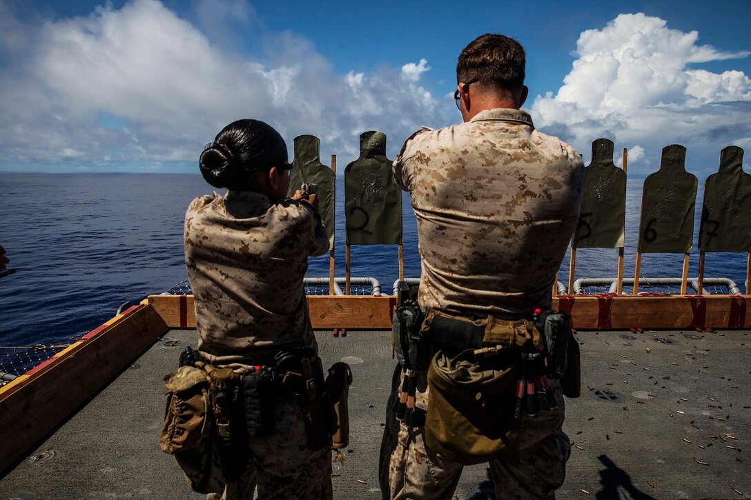 Gunnery Sgt. Robert Turek, right, teaches Midshipman Jessica Gonzalez how to operate the 1911 pistol aboard the USS Essex (LHD 2) at sea in the Pacific Ocean, June 1, 2015. Turek is with the 15th Marine Expeditionary Unit’s Maritime Raid Force and Gonzalez is a midshipman from San Antonio, Texas. Gonzalez is aboard the USS Essex during summer training for the Reserve Officers’ Training Corps. (U.S. Marine Corps photo by Cpl. Anna Albrecht/Released)