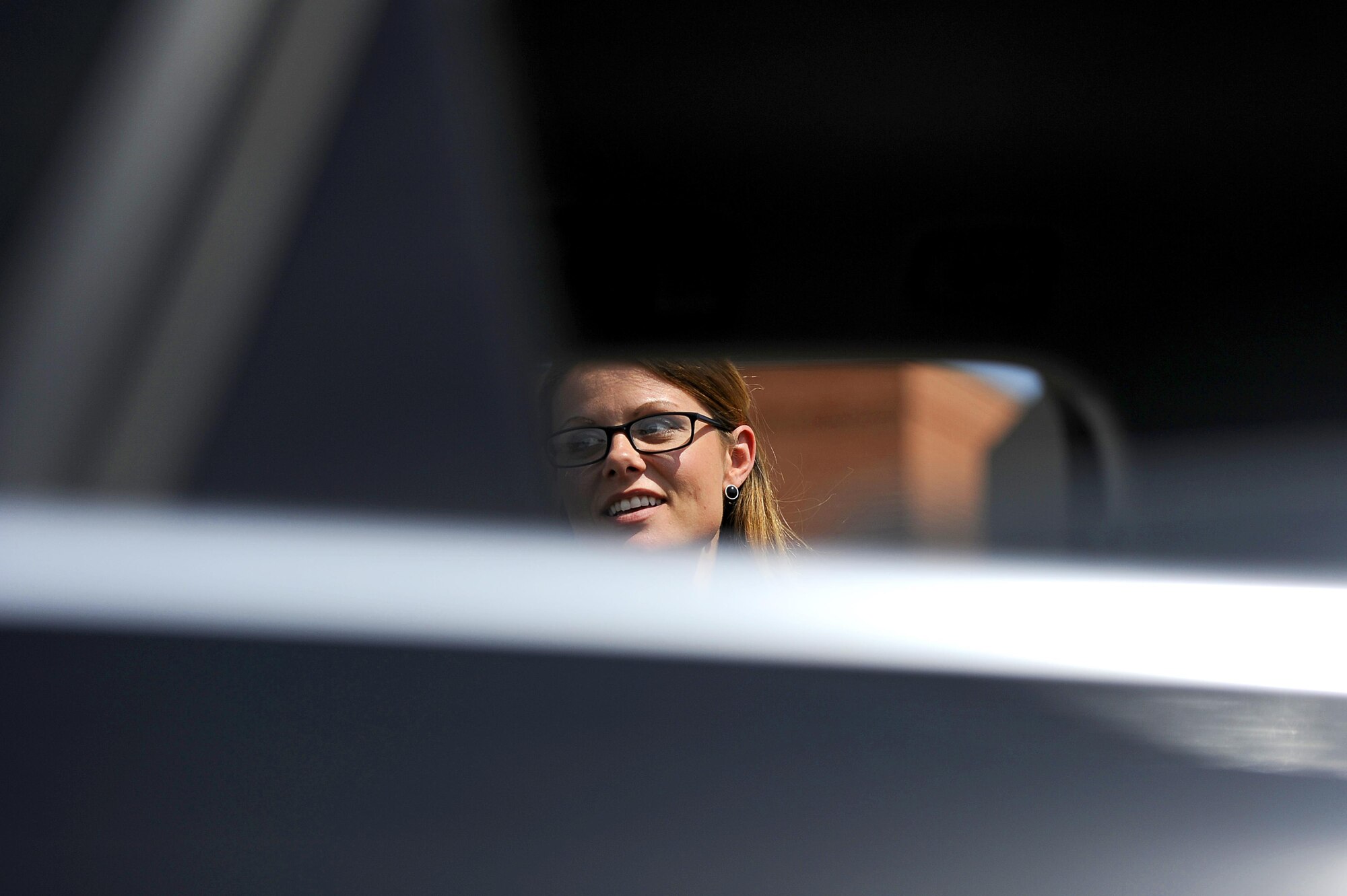 Michelle Brooks, 315th Training Squadron contractor, looks inside an unattended car while following the sound of a crying baby in the commissary parking lot on Goodfellow Air Force Base, Texas, May 29, 2015. The 17th Medical Group Family Advocacy Program conducted a social experiment to see how people would respond to an infant left in a car. They used a decoy infant and a crying baby audio track. The goal was to raise awareness of how dangerous leaving a child in a car can be. (U.S. Air Force photo by Tech. Sgt. Austin Knox/Released)