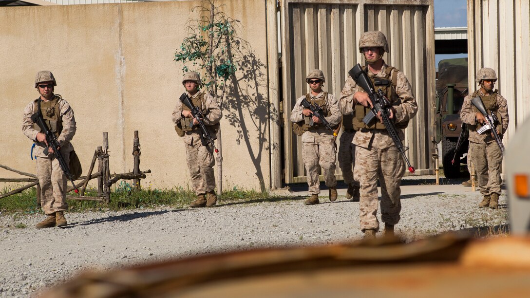 Marines with 1st Battalion, 10th Marine Regiment, begin their patrol through a mock village during Infantry Immersion Training aboard Camp Lejeune, N.C., May 29, 2015.  The immersion center is an indoor Military Operation on Urban Terrain environment that allows Marines to go through a life-like village and encounter role-players to better sharpen their MOUT skills.  (U.S. Marine Corps Photo by Cpl. Michael Dye/Released)