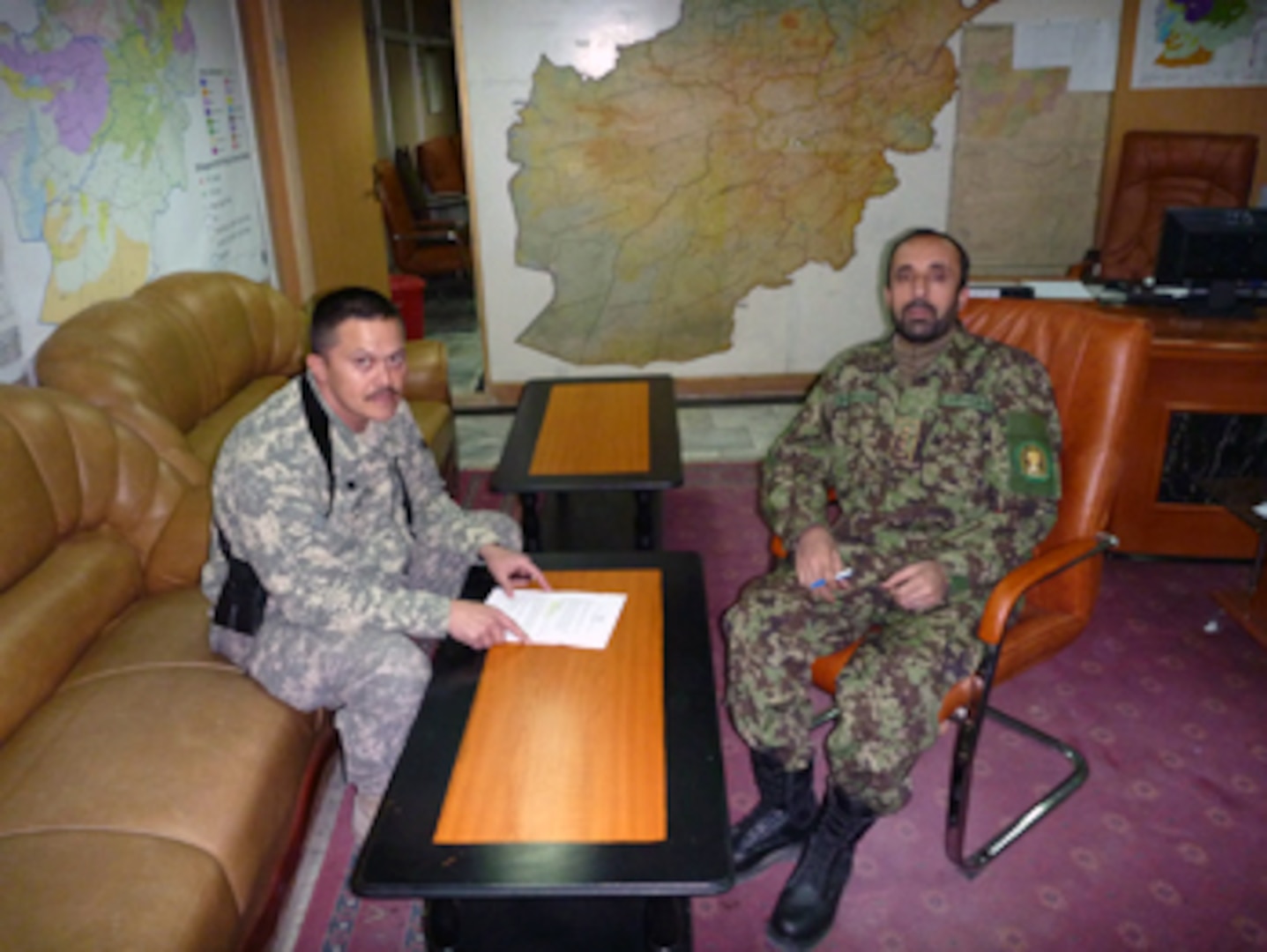 Army Lt. Col. Paul Loftus of the Virginia National Guard and Afghan Col. Qadir discuss daily operations at the NMCC Headquarters in Kabul, Afghanistan.