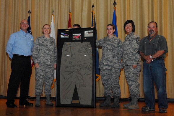 Michael Looney, San Angelo Chamber of Commerce Marketing and Recruiting vice president, and Douglas Burdette, Showdown in San Angelo Drag Boat Races volunteer, present U.S. Air Force Col. Kimberlee P. Joos, 17th Training Wing Commander, with the Waders Award during a volunteer recognition event at the base theater on Goodfellow Air Force Base, Texas, June 1, 2015. The Chamber of Commerce bought the waders to keep volunteers warm while they loaded and unloaded boats during the last race season in September, 2014. (U.S. Air Force photo by Senior Airman Joshua Edwards/Released)