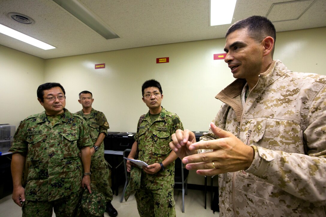 U.S. Marine Maj. Giuseppe E. Stavale details the role of the 3rd Law Enforcement Battalion in the III MEF mission to Japanese members of 136th Military Police, Japan Ground Self Defense Force during a tour May 28 on Camp Hansen, Okinawa, Japan. The visitors were treated to a tour of the camp and a demonstration of the tools that the 3rd LEB employs. Stavale is the executive officer for 3rd LEB, III MEF.