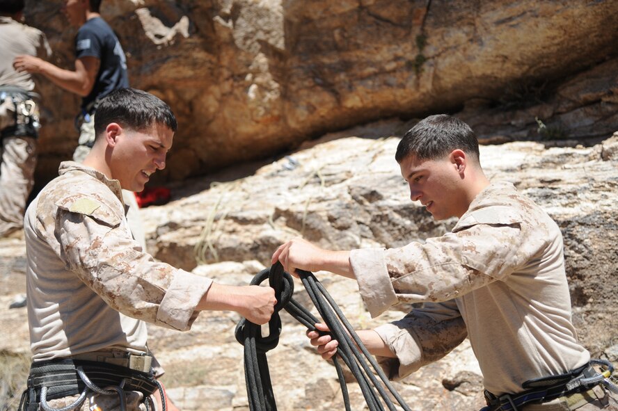 U.S. Marines Corps Cpls. Dave and Dan Peete, reconnaissance Marines, work together to tie a football knot during Angel Thunder 2015 high angle rescue training at Mount Lemmon, Ariz., June 1, 2015. During the training, U.S. Marines and U.S. Airmen practiced tying knots, anchoring ropes, rappelling down a cliffside unassisted, and returning to the initial elevation point. Angel Thunder is an Air Combat Command-sponsored personnel recovery exercise for combat air force, joint, allied and interagency participants. The Peetes’ are assigned to Force Company, 1st Reconnaissance Battalion, 1st Marine Division at Camp Pendleton, Calif. (U.S. Air Force photo by Senior Airman Betty R. Chevalier/Released)