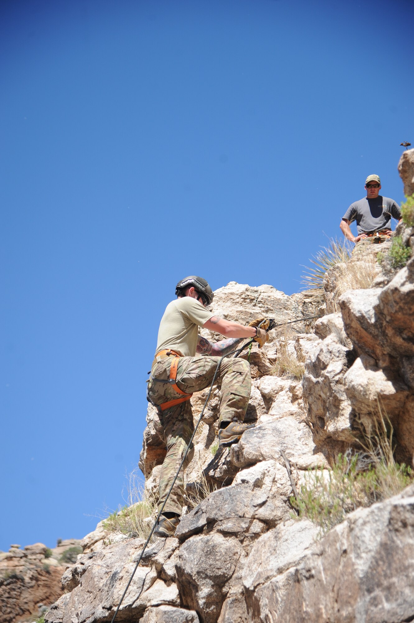 U.S. Air Force Senior Airman Miles Roberts observes Senior Airman Austin Sanders ascend a cliffside during  Angel Thunder 2015 high angle rescue training at Mount Lemmon, Ariz., June 1, 2015. During the training, U.S. Marines and U.S. Airmen practiced tying knots, anchoring ropes, rappelling down a cliffside unassisted, and returning to the initial elevation point. Angel Thunder is an Air Combat Command-sponsored personnel recovery exercise for combat air force, joint, allied and interagency participants. Roberts and Sanders are both reserve pararescuemen assigned to the 304th Rescue Squadron at Portland Air National Guard Base, Ore. (U.S. Air Force photo by Senior Airman Betty R. Chevalier/Released)