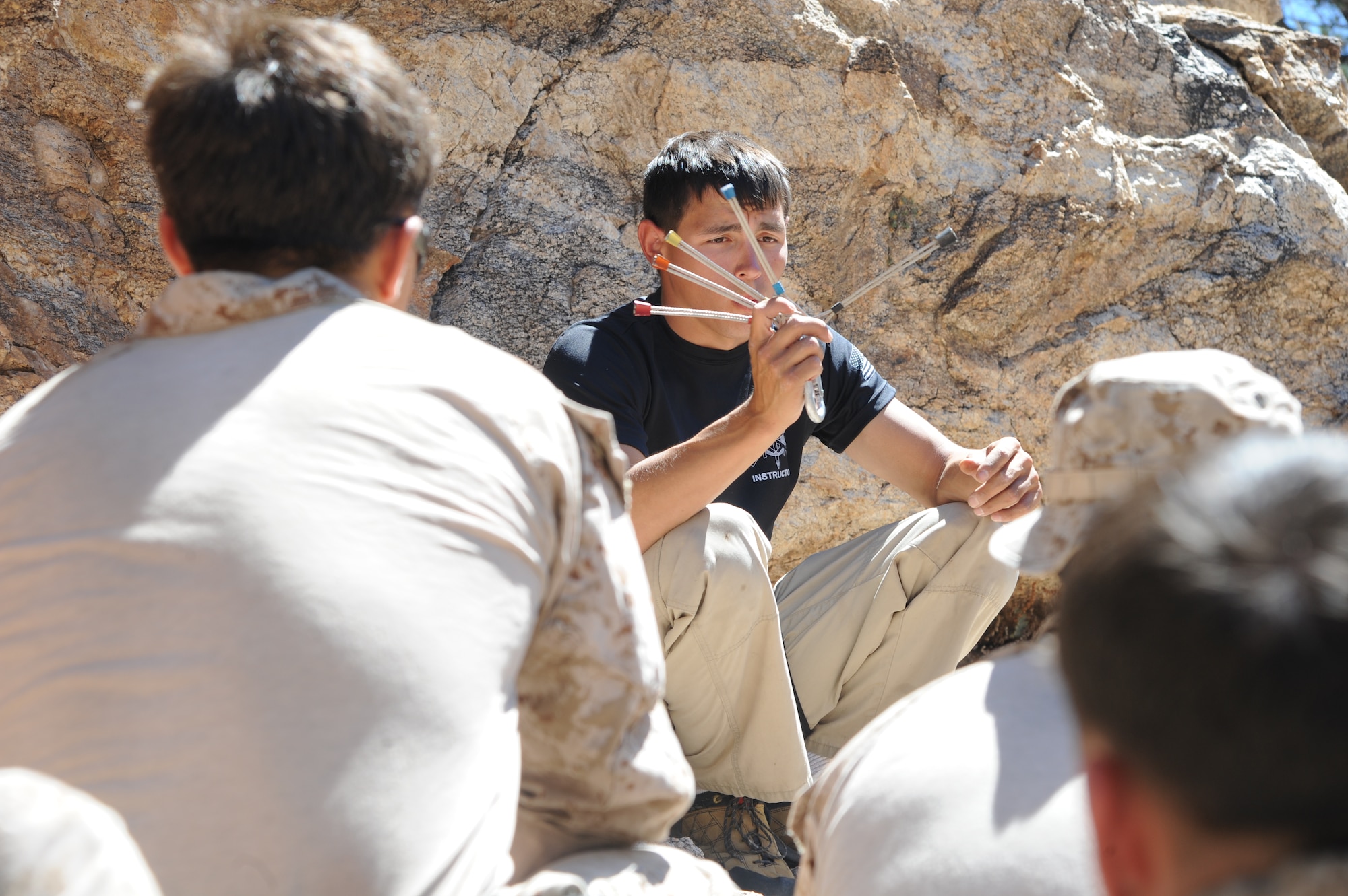 U.S. Marine Corps Sgt. Adam Martinez, Expeditionary Operations Training Group instructor, teaches a group of fellow Marines about improvised rappel anchors during Angel Thunder 2015 high angle rescue training at Mount Lemmon, Ariz., June 1, 2015. During the training, U.S. Marines and U.S. Airmen practiced tying knots, anchoring ropes, rappelling down a cliffside unassisted, and returning to the initial elevation point. Angel Thunder is an Air Combat Command-sponsored personnel recovery exercise for combat air force, joint, allied and interagency participants. The Marines are assigned to Force Company, 1st Reconnaissance Battalion, 1st Marine Division at Camp Pendleton, Calif. (U.S. Air Force photo by Senior Airman Betty R. Chevalier/Released)
