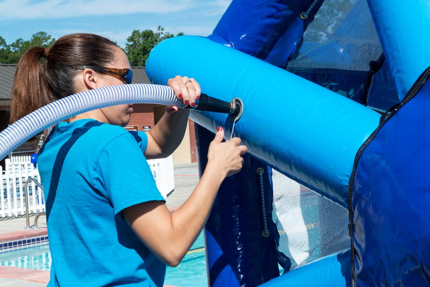 Amber Dexheimer, 23d Force Support Squadron community programmer, pumps the water wheel with air before the water wheel challenge June 1, 2015 at Moody Air Force Base, Ga. U.S. Air Force Col. Chad Franks, 23d Wing commander, participated in the challenge to give the Airmen participating in the Build a Boat event on June 18, a chance to win the opportunity to use his parking spot for a week. (U.S. Air Force photo by Airman 1st Class Kathleen D. Bryant)