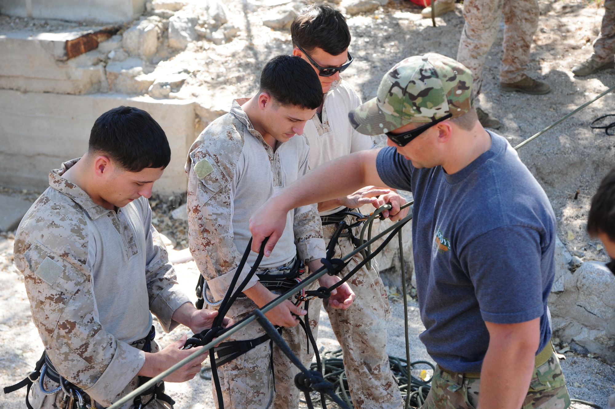 U.S. Air Force Senior Airman Miles Roberts, reserve pararescueman, assists U.S. Marine Corps Cpl. Dan Peete, reconnaissance Marine, tie a knot designed to stay secure while rappelling during Angel Thunder 2015 high angle rescue training at Mount Lemmon, Ariz., June 1, 2015. During the training, U.S. Marines and U.S. Airmen practiced tying knots, anchoring ropes, rappelling down a cliffside unassisted, and returning to the initial elevation point. Angel Thunder is an Air Combat Command-sponsored personnel recovery exercise for combat air force, joint, allied and interagency participants. Roberts is assigned to the 304th Rescue Squadron at Portland Air National Guard Base, Ore., and Peete is assigned to Force Company, 1st Reconnaissance Battalion, 1st Marine Division at Camp Pendleton, Calif. (U.S. Air Force photo by Senior Airman Betty R. Chevalier/Released)