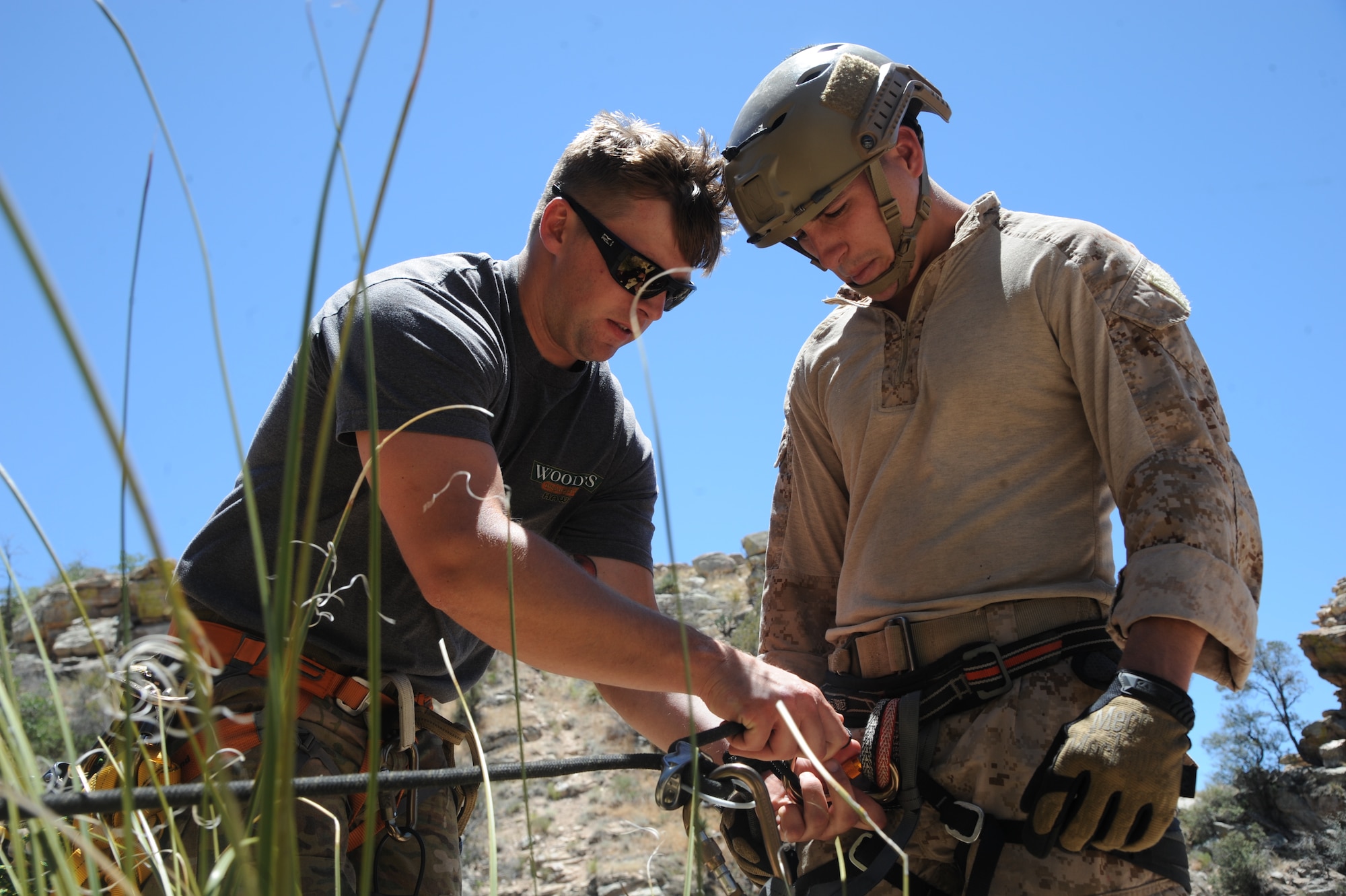 U.S. Marine Corporal Dan Peete, reconnaissance Marine, observes as U.S. Air Force Senior Airman Miles Roberts, reserve pararescueman, secures his harness to the rope during Angel Thunder 2015 high angle rescue training at Mount Lemmon, Ariz., June 1, 2015. Exercise Angel Thunder is the world’s largest personnel recovery exercise, hosting 11 partner nations and nine inter-agencies at Davis-Monthan Air Force Base in Tucson, Ariz.  Peete is assigned to Force Company, 1st Reconnaissance Battalion, 1st Marine Division at Camp Pendleton, Calif. and Roberts is assigned to the 304th Rescue Squadron is stationed at Portland Air National Guard Base, Ore.  (U.S. Air Force photo by Tech. Sgt. Courtney Richardson/Released)