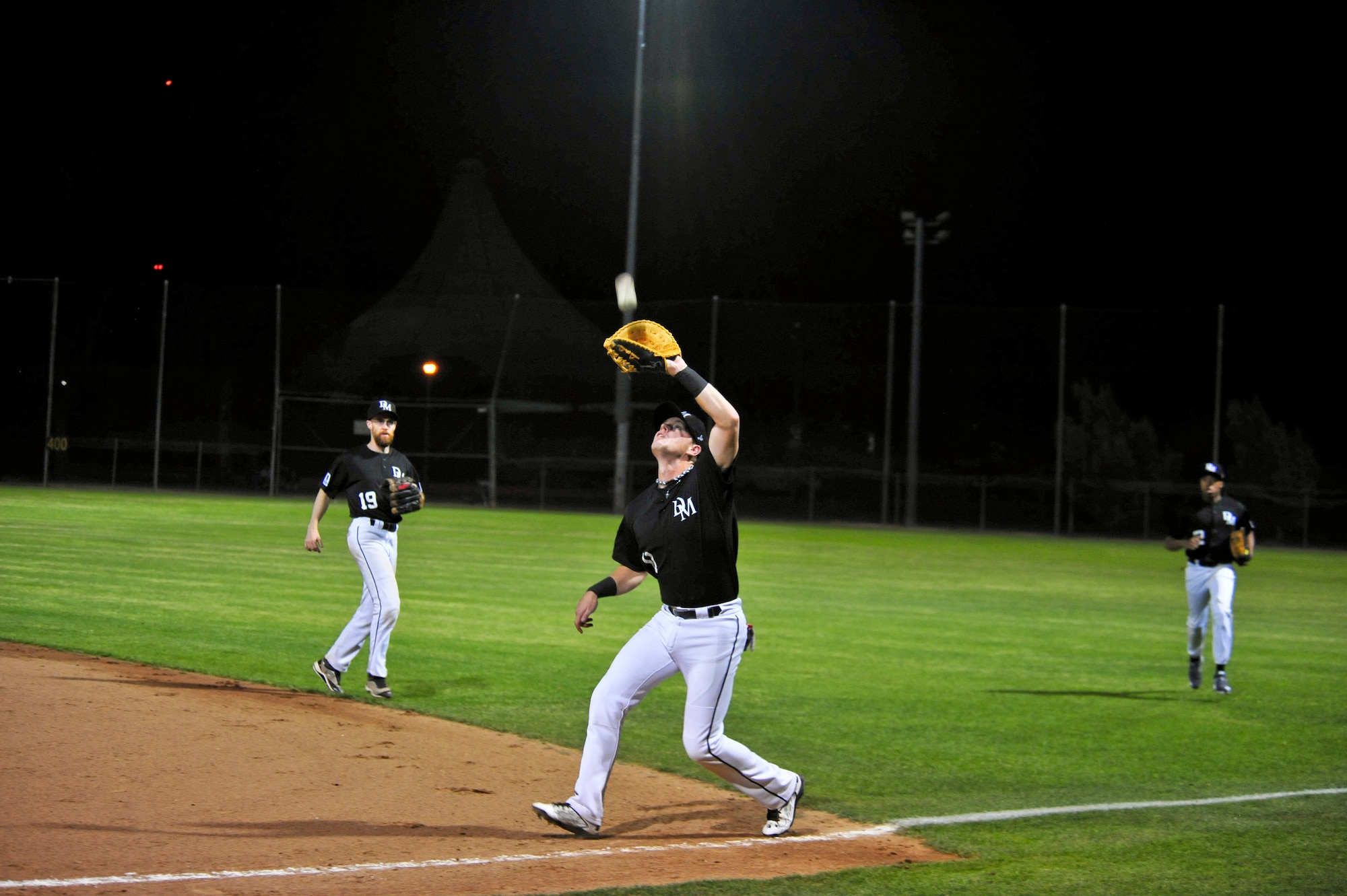 U.S. Air Force Senior Airman Russell LewisPablo, 25th Operational Weather Squadron weather forecaster and resource protection specialist, catches an infield fly ball during a baseball game at Reid Park, Tucson, Ariz., April 10, 2015. LewisPablo was one of five Airmen selected to play with the U.S. Military All-Stars baseball team.(U.S. Air Force photo by Airman 1st Class Chris Massey/Released)