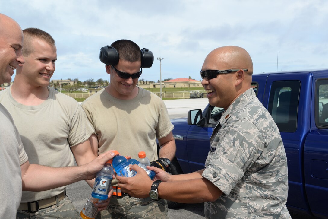 Chaplain (Maj.) Dennis DeGuzman, 36th Wing, passes out sports drinks to Airmen, June 2, 2015, at Andersen Air Force Base, Guam. During their unit visits, religious support teams offer water, sports drinks and popsicles to Airmen as a way to enable stress-free conversations during rest periods. (U.S. Air force photo by Senior Airman Amanda Morris/Released) 