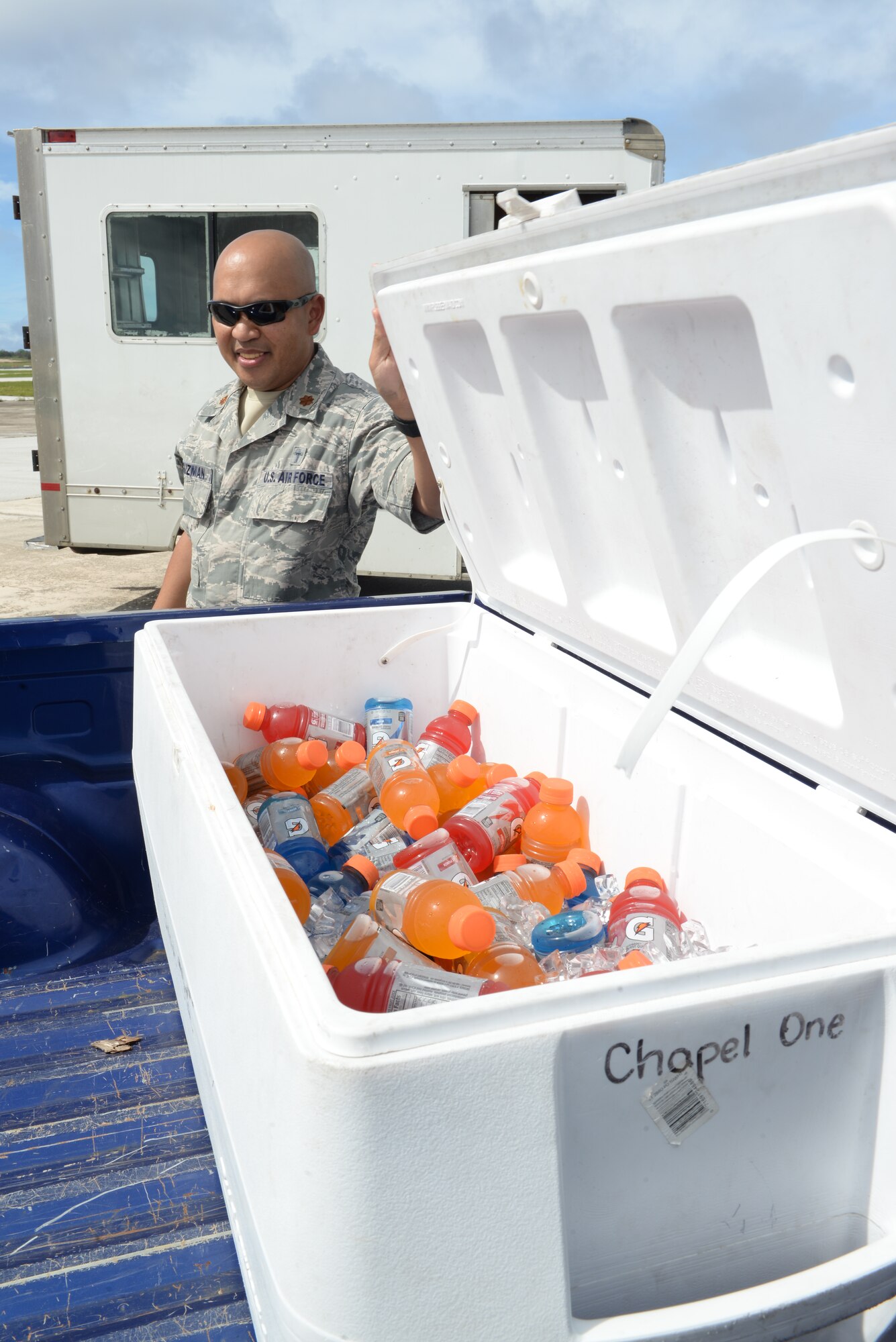 Chaplain (Maj.) Dennis DeGuzman, 36th Wing, passes out sports drinks to Airmen, June 2, 2015, at Andersen Air Force Base, Guam. During their unit visits, religious support teams offer water, sports drinks and popsicles to Airmen as a way to enable stress-free conversations during rest periods. (U.S. Air force photo by Senior Airman Amanda Morris/Released) 