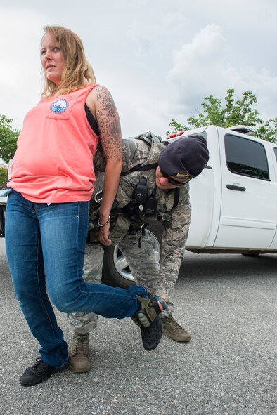 U.S. Air Force Staff Sgt. Renee Mansour, 23d Security Forces Squadron military working dog handler, searches the suspect, played by Staff Sgt. Lyndsay Gebhart, during an anti-robbery exercise June 1, 2015, at Moody Air Force Base, Ga. Mansour found and seized money stolen from a cash register on the suspect during the search. (U.S. Air Force photo by Airman 1st Class Ceaira Tinsley/Released)
