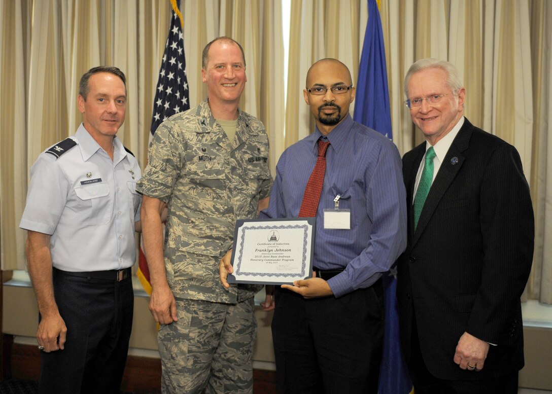 Franklyn Johnson, center right, Edible Arrangements Suitland, Md., manager and honorary commander, receives a certificate from Col. Mark Muth, center left, 779th Dental Squadron commander; Col. Bradley Hoagland, far left, 11th Wing/Joint Base Andrews commander; and Jim Estepp, far right, Andrews Business & Community Alliance president and chief executive officer and Senior Andrews Ambassador, May 29, 2015, at The Club, Joint Base Andrews, Md. The Joint Base Andrews Honorary Commander Program encourages an exchange of ideas and experiences, as well as partnerships between key leaders of the base's surrounding communities, JBA commanders and Airmen.  (U.S.  Air Force photo by Senior Airman Preston Webb/RELEASED)