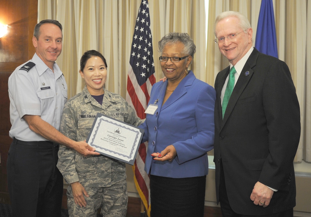 Carolyn Lowe, center right, District V Coffee Club facilitator, receives a certificate from Col. Lee Zimmerman, Air Force Legal Operations Agency vice commander; Col. Bradley Hoagland, far left, 11th Wing/Joint Base Andrews commander; and Jim Estepp, far right, Andrews Business & Community Alliance president and chief executive officer and Senior Andrews Ambassador, May 29, 2015, at The Club, Joint Base Andrews, Md. The Joint Base Andrews Honorary Commander Program encourages an exchange of ideas and experiences, as well as partnerships between key leaders of the base's surrounding communities, JBA commanders and Airmen.  (U.S.  Air Force photo by Senior Airman Preston Webb/RELEASED)