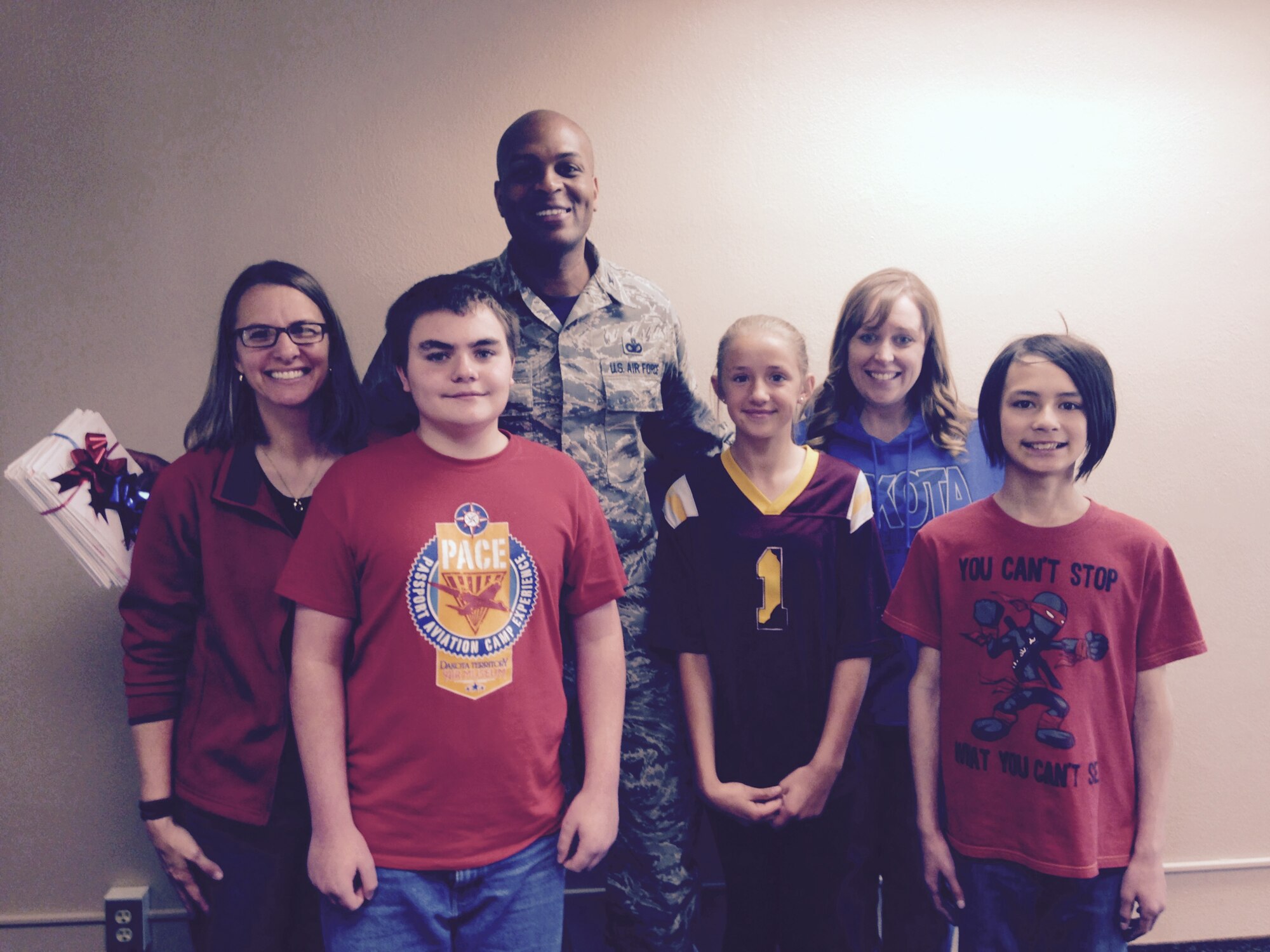 Kathryn Lenertz, Dakota Elementary School principal, Col. Roy Collins, 5th Mission Support Group commander, and Jade Feller, Dakota Elementary School counselor, take a photo with participants of the random acts of kindness event, James Townsend, Taylor Link and Benito Isla at Minot Air Force Base, N.D., June 2, 2015. At the beginning of May, the students learned about what RAOKs are and how they can make a difference. (Courtesy photo)  