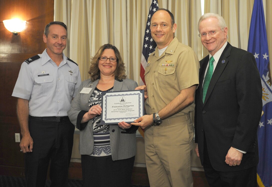 Francesca Pellegrino, center left, Catholic Coalition for  Special Education president and founder, receives a certificate from Capt. Anthony Gilbert, center right, Naval Air Facility Washington commander; Col. Bradley Hoagland, far left, 11th Wing/Joint Base Andrews commander; and Jim Estepp, far right, Andrews Business & Community Alliance president and chief executive officer and Senior Andrews Ambassador, May 29, 2015, at The Club,  Joint Base Andrews, Md. The Joint Base Andrews Honorary Commander Program encourages an exchange of ideas and experiences, as well as partnerships between key leaders of the base's surrounding communities, JBA commanders and Airmen.  (U.S.  Air Force photo by Senior Airman Preston Webb/RELEASED)