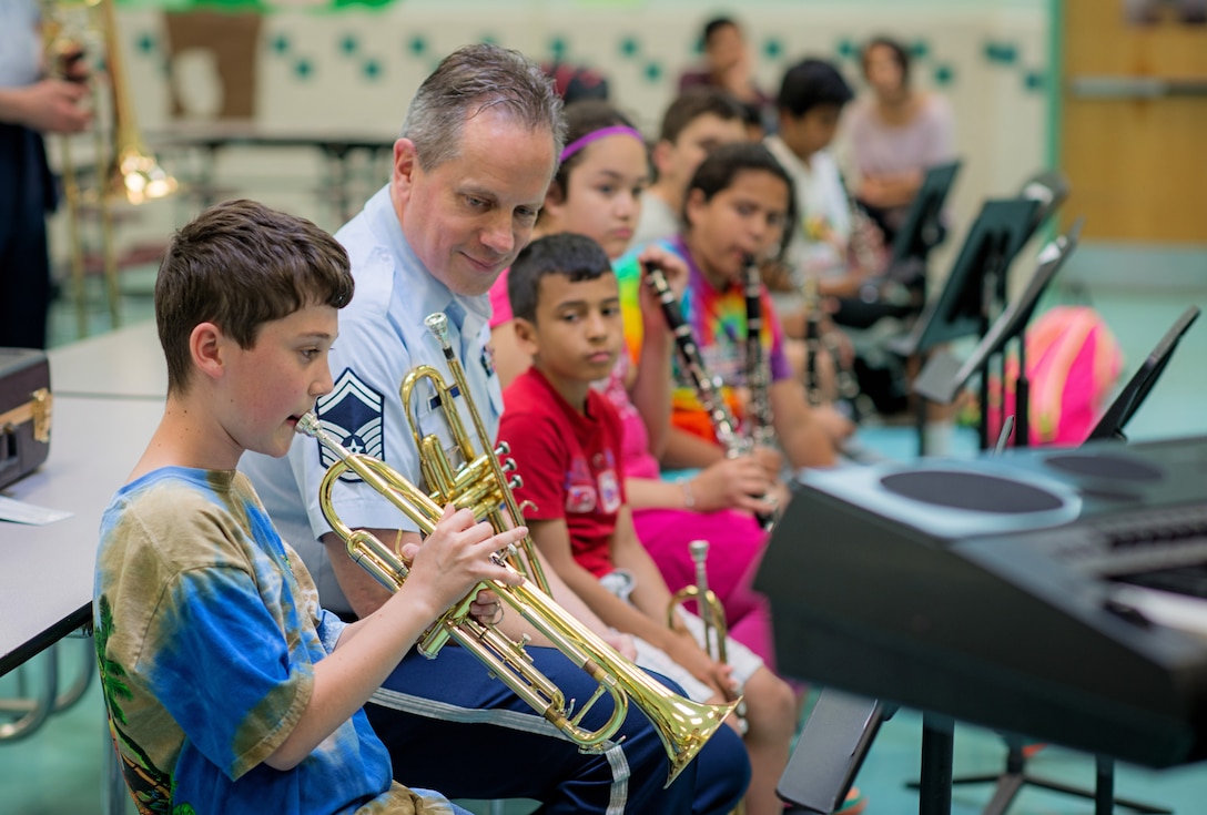 Senior Master Sgt. Kevin Burns works with students from Cunningham Park Elementary, as part of the school's BRIDGES after school program. This is an intensive program that seeks to develop the intellectual, social, and personal identities of children and youth through the pursuit of musical excellence. (U.S. Air Force Photo/released)