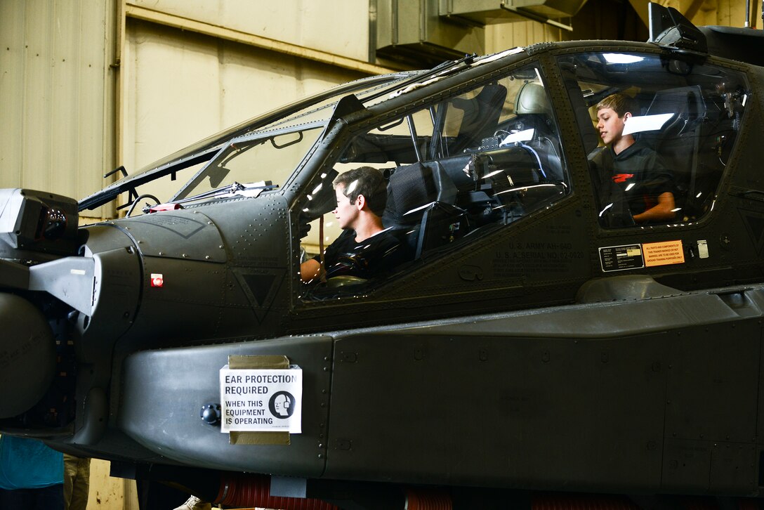 High school students from the local area sit in an A-64 Delta model helicopter during a mission orientation day at Fort Eustis, Va., May 29, 2015. While inside of the helicopter, students were able to observe the aircraft’s various controls and equipment.  (U.S. Air Force photo by Senior Airman Kimberly Nagle/Released)  