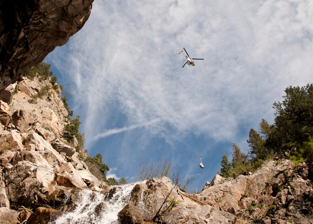 CHEYENNE MOUNTAIN AIR FORCE STATION, Colorado – A “Lama” helicopter designed for high elevation, lifts equipment in and out of the canyons where ring nets are to be installed, May, 28, 2015. The five ring nets are one of four steps in the mitigation process to reduce the damage of future landslides. The ring nets, 15-foot deep main catchment basin, a culvert down the mountain into the storm water system and infrastructure protection are being built as a result of landslides that struck the mountain Sept. 12, 2013, following torrential rain. (U.S. Air Force photo by Senior Airman Tiffany DeNault)
